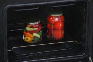 Die besten Möglichkeiten, Tomaten in Gläsern zu sterilisieren, und die Dauer des Verfahrens